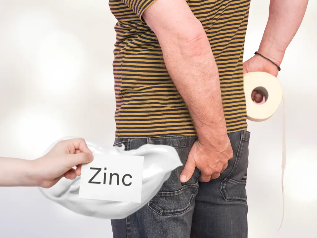 Man holding a toilet paper and holding his bum from hemorrhoids pain and a zinc oxide cream